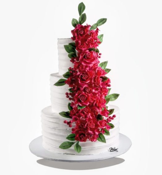 White elegant cake with red roses.
